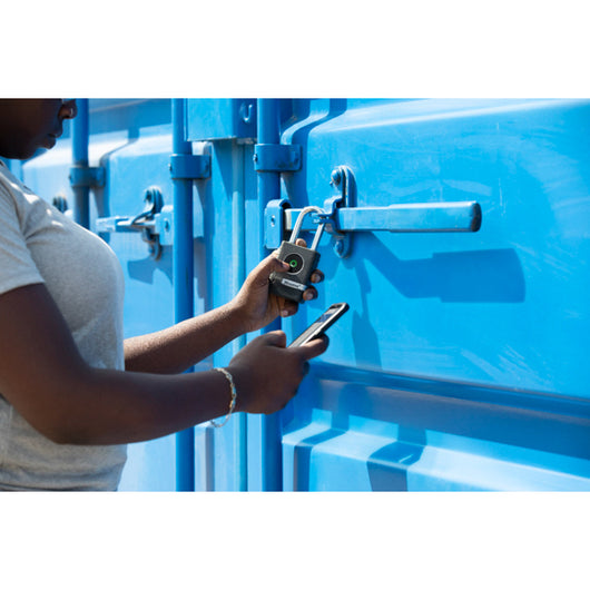 Person using a smartphone app to lock a blue storage container with smart padlock.