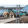 Construction site with heavy machinery behind a chain-link fence, smart keyless padlocked securing site.